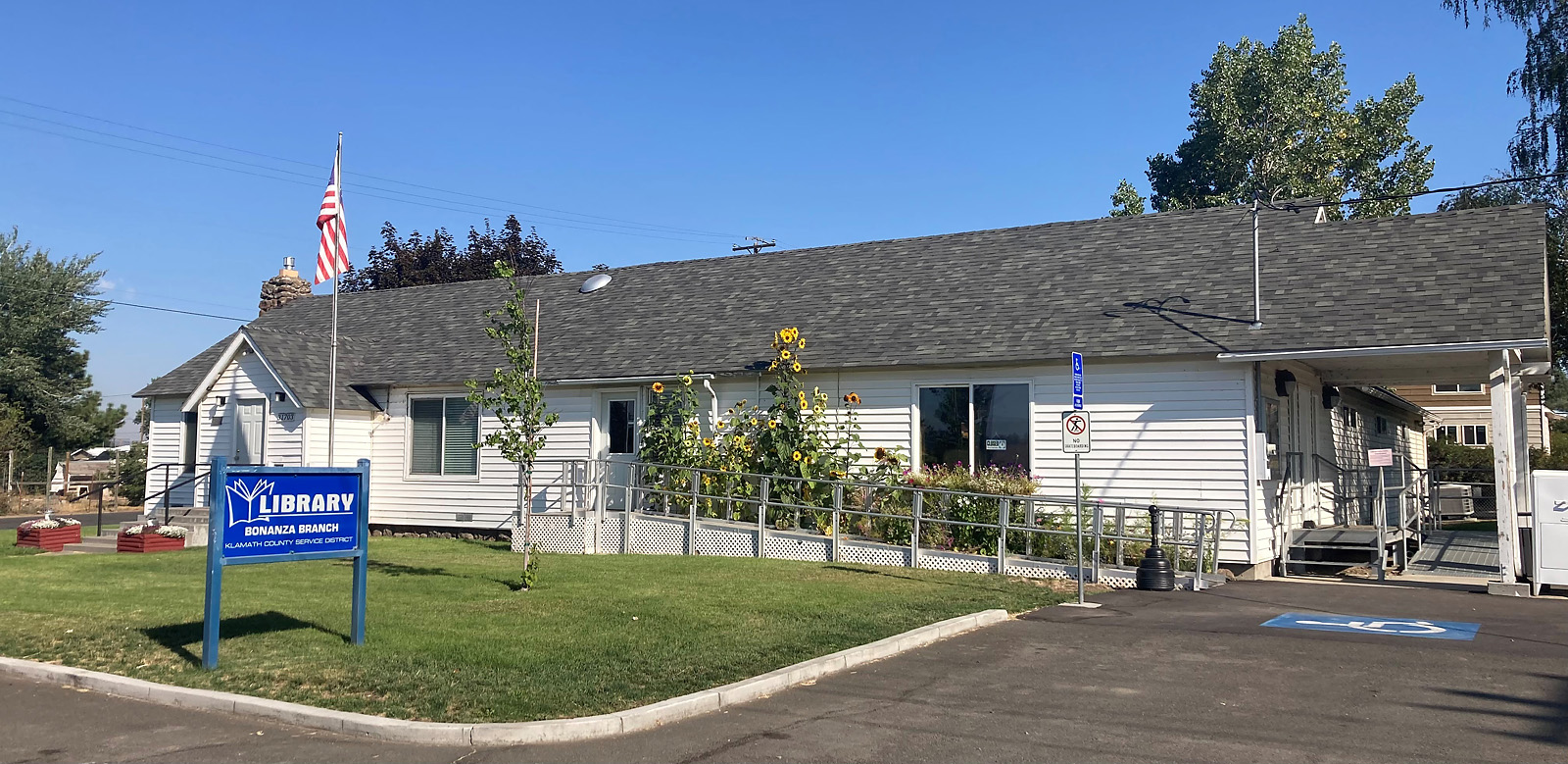 Bonanza Branch Library Building Exterior with Flowers and Library Sign in Front