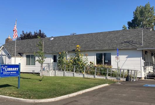 Bonanza Branch Library Building Exterior with Flowers and Library Sign in Front