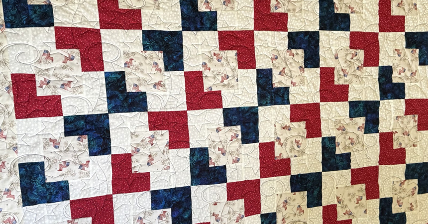 A photo of the quilt pattern: layered squares in red, white, blue and American flag print fabric.