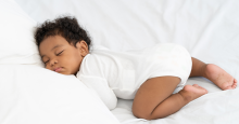 A baby sleeping on their tummy.